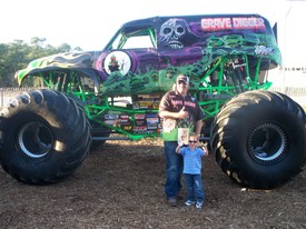 Fri 27 Feb 2009 06:31:27 PM

Grave Digger is Andrew's favorite monster truck.  This is Andrew and Dennis, one of Grave Digger's drivers.  Andrew got an autographed picture, also, which he is holding, along with his Grave Digger toy, in this photo.